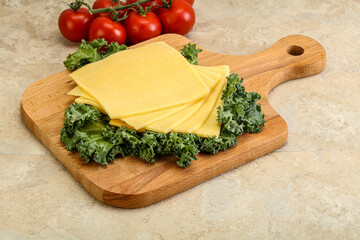 Sliced Gauda cheese over board