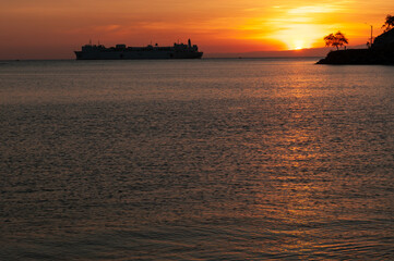 Naklejka premium sunset on the beach with silhouette of ship on the ocean at Dili Timor Leste