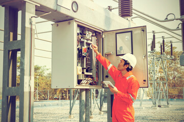 Electrical engineers inspect 115 kv breaker control cabinets in high voltage substations using a...