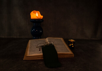 Burning candle and an open old book