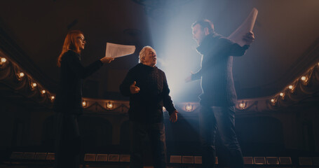 Elderly director supporting actors during quarrel scene