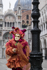 Fototapeta na wymiar Venice, Italy - February 17, 2020: An unidentified person in a carnival costume in Piazza San Marco attends at the Carnival of Venice.