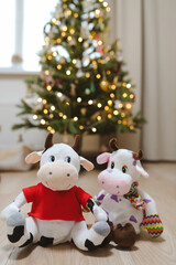 Toy bull against the blured Christmas tree lights. Symbol of the Chinese New year 2021. Merry Christmas and New year background