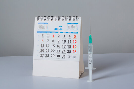 Coronavirus vaccine calendar with syringe on white background