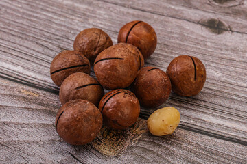 Brown macadamia nut heap over background