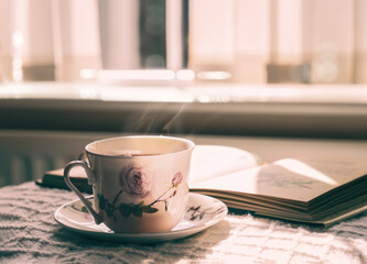 Hot tea with steaming in cinematic tone, Still life cuppa tea with steam on a coffee table with morning light shining from window, Cozy scene of relaxing in afternoon in tearoom