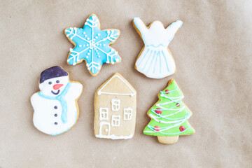 Gingerbread painted colored gingerbread cookies and spices and snowflakes on a craft background close-up. Christmas celebration concept. New Year's food.