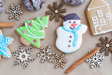 Gingerbread painted colored gingerbread cookies and spices and snowflakes on a craft background close-up. Christmas celebration concept. New Year's food.