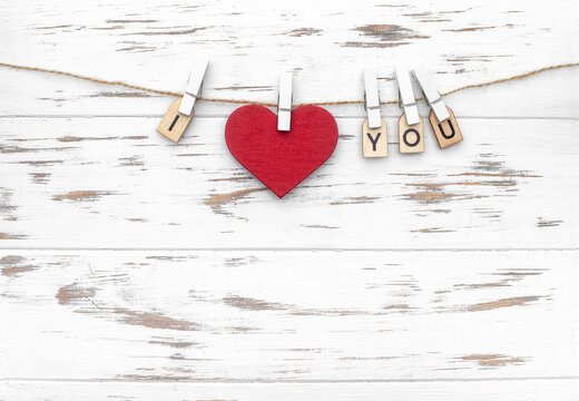 The word I love you with wooden letters and a heart shape. Love theme. Wooden cubes with the word on pegs