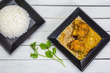 Bengali cuisine - doi katla (catla fish curry with yogurt) in a plate served with white rice with...