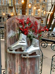 Christmas silver skates with decorative red berries.