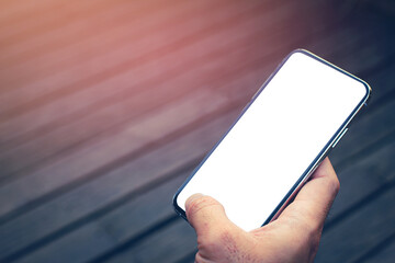 Close up of men hands holding touching mobile phone with blank copy space for your text message in cafe  with light Sunset,Vintage tone.Selective focus