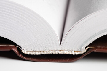 Close-up of the hardback of a thick book on a gray background. Reading and libraries