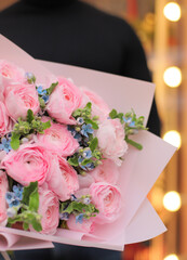 Colorful flowers assorted bouquet of oxypetalum and ranunculus in pink paper. Holiday celebration concept. Bouquet of beautiful flowers in hands. Colorful flowers bouquet wrapped in paper