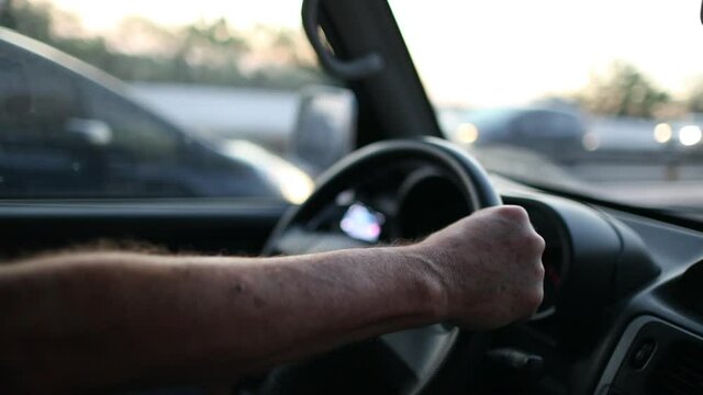 Close-up Man hands holding steering wheel driving on road
