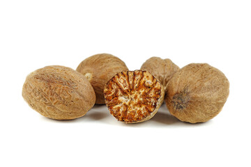 Grated half and whole nutmegs isolated on a white background closeup