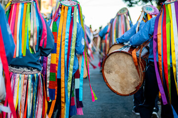 Fitas coloridas e pessoas tocando tambores na Congada, manifestação cultural e religiosa...