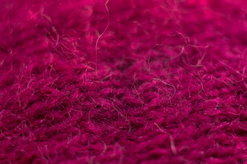 Knitted wool fabric texture background. Soft focus. Macro blur background. Burgundy woolen hand-knitted