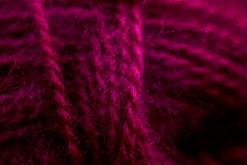 Knitted wool fabric texture background. Soft focus. Macro blur background. Burgundy woolen hand-knitted