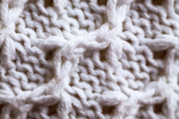 Knitted wool fabric texture background. Soft focus. Macro blur background. White woolen hand-knitted