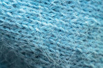 Knitted wool fabric texture background. Soft focus. Macro blur background. Blue woolen hand-knitted