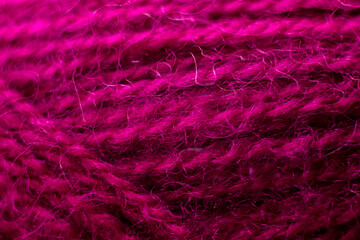 Knitted wool fabric texture background. Soft focus. Macro blur background. Burgundy threads for knitting