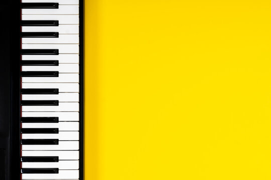 Top view to piano keyboard on yellow background. Music learning concept. Top view