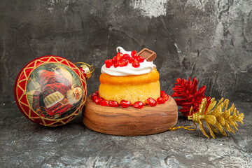 front view berry cake golden and red pinecones red xmas tree ball on grey-white background with copy space