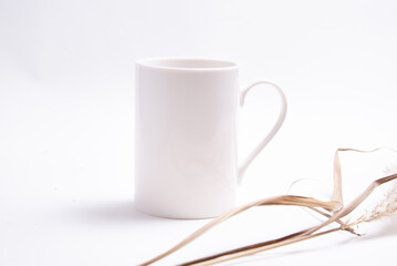 White porcelain coffee cup decorated with dried grass
