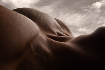 Mountain. Detailed texture of human skin. Close up of young african-american male body surface like landscape with the sky on background. Skincare, bodycare, healthcare, inspiration, fantasy artwork.