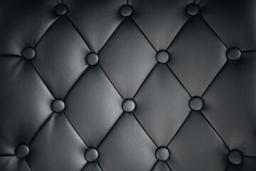 Close-up of an elegant vintage Chesterfield pattern black leather sofa