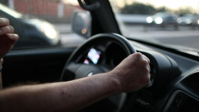 man hands holding steering wheel driving on road, close-up hand
