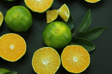Fototapeta na wymiar Green sweet tangerines growing with background