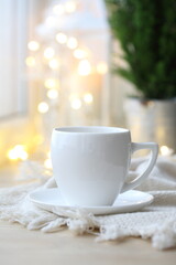 Coffee cup on the background of the Christmas garland