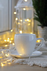 Coffee cup on the background of the Christmas garland