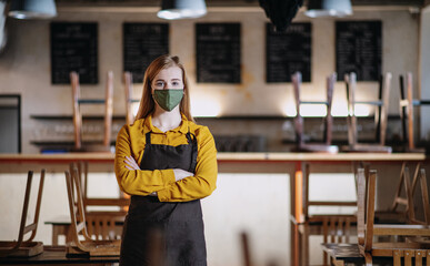 Frustrated waitress standing in closed cafe, small business lockdown due to coronavirus.
