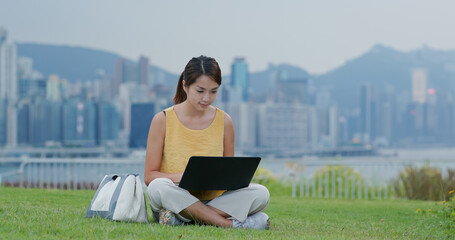 Woman work on laptop computer at park