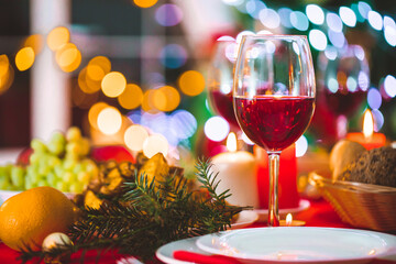 Close up of decorated Christmas dinner table with glasses of red wine