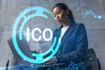 Businesswoman typing on laptop work in modern office on new project. ICO icon drawing hologram. Double exposure. Concept of success.