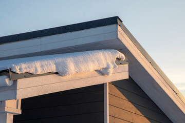 Gray wooden house roof with snow on it