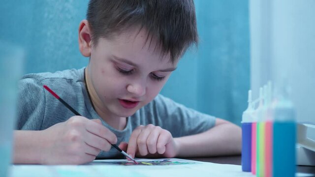 the boy paints with a brush. school of the arts. educational activities with the child.