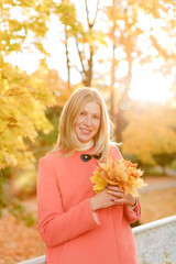 Woman in the autumn park. Girl on a background of fall. Autumn yellow and red leaves