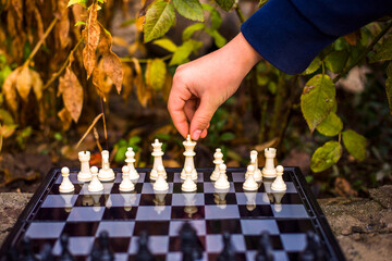 Close-up man hand  playing chess in nature