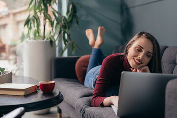 Naklejka premium woman enjoying time working on laptop computer at her home