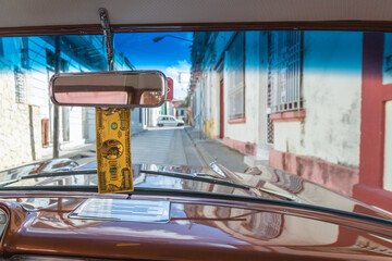 driving on the streets of santiago de cuba in a classic car