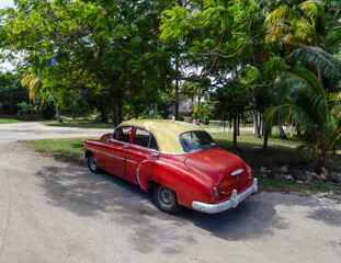 classic car parking under a tree in santiago de cuba, cuba
