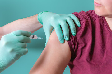 Nurse vaccinating woman in vaccine center of hospital