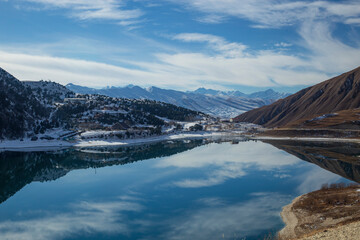 A lake high in the mountains in winter with the blue sky and reflection in the water