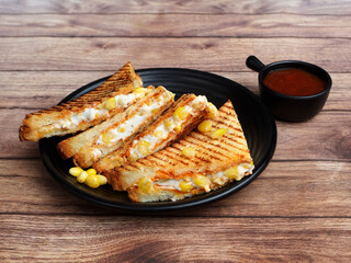 Sweet corn grilled sandwich served with ketchup, isolated over a rustic wooden background, selective focus