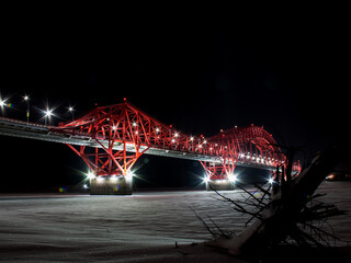 Bridge over the frozen Irtysh river 'Red Dragon'. A huge bridge hangs over the frozen river at night. Khanty-Mansi Autonomous Okrug - Yugra.